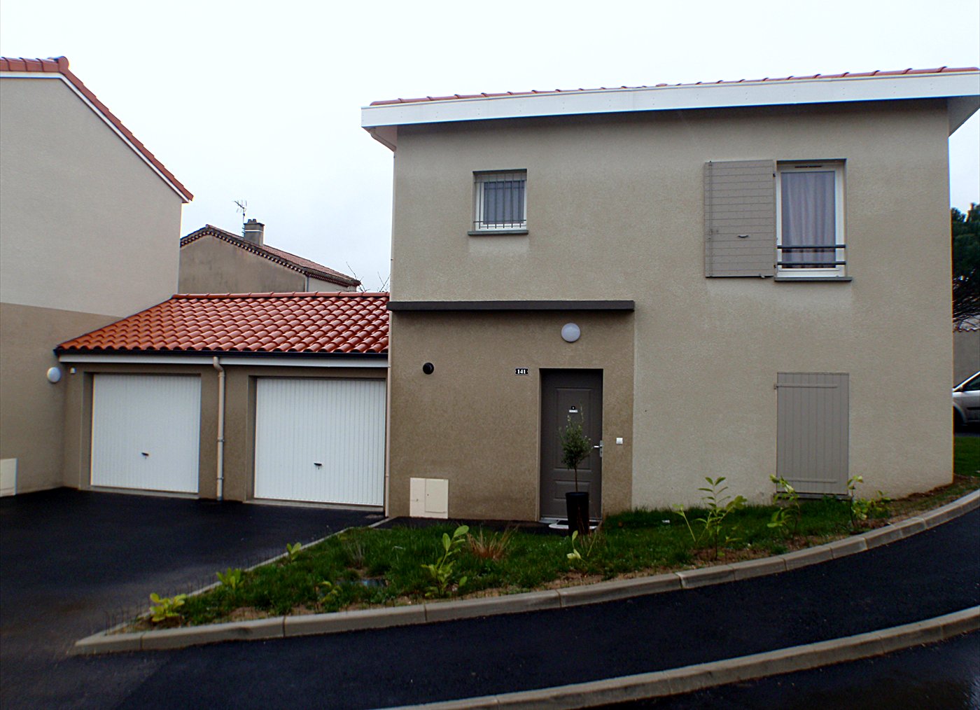 Maison neuve terminée : couverture en tuiles, garages, porte d&rsquo;entrée et volets, faÃ§ade enduite